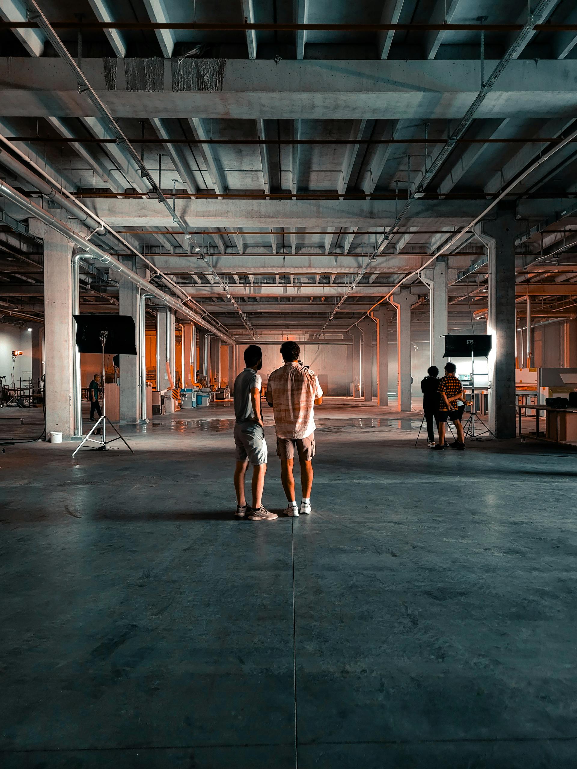 A cinematic scene captures an old factory repurposed into a film set with dramatic lighting.